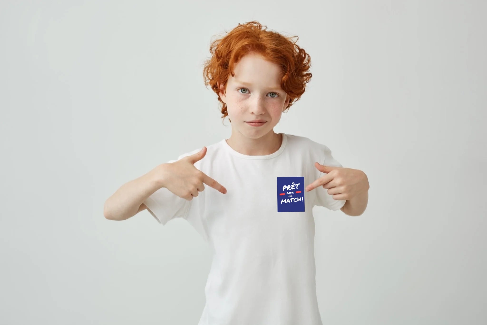 gros-plan-d-un-garcon-mignon-aux-cheveux-rouges-avec-des-taches-de-rousseur-pointant-avec-les-doigts-sur-un-t-shirt-blanc-avec-une-expression-serieuse-et-confiante-copiez-l-espace