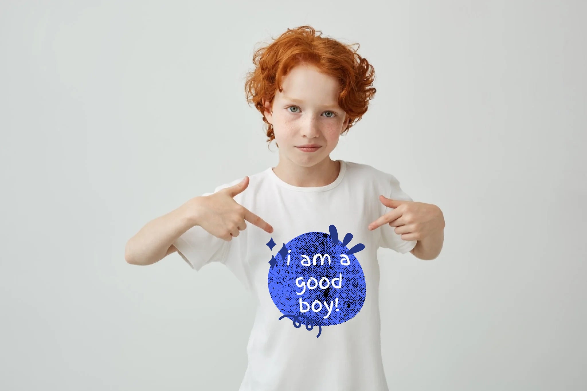 gros-plan-d-un-garcon-mignon-aux-cheveux-rouges-avec-des-taches-de-rousseur-pointant-avec-les-doigts-sur-un-t-shirt-blanc-avec-une-expression-serieuse-et-confiante-copiez-l-espace
