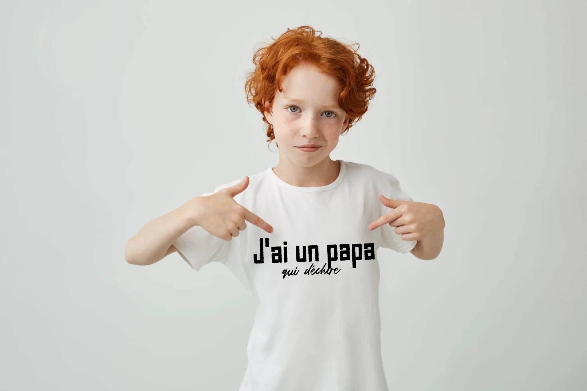 gros-plan-d-un-garcon-mignon-aux-cheveux-rouges-avec-des-taches-de-rousseur-pointant-avec-les-doigts-sur-un-t-shirt-blanc-avec-une-expression-serieuse-et-confiante-copiez-l-espace